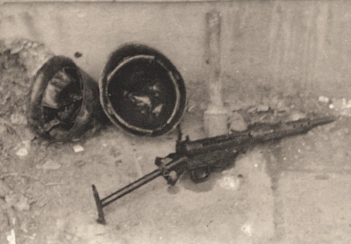 Dwa polskie hełmy i karabin Sten wydobyte z kanału burzowego przy ul. Agrykola podczas ekshumacji poległych powstańców warszawskich, 1945 r. Fot. AIPN