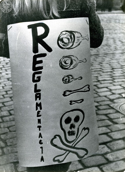 Demonstrantka z grafiką przedstawiającą czaszkę ze skrzyżowanymi piszczelami, kawałkami mięsa oraz z napisem „REGLAMENTACJA”. Grudziądz, październik 1981 r. (fot. zasobu AIPN)