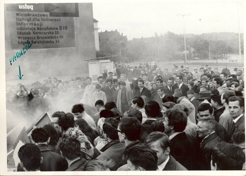 Grupa ludzi skupionych wokół zniszczonego elementu.