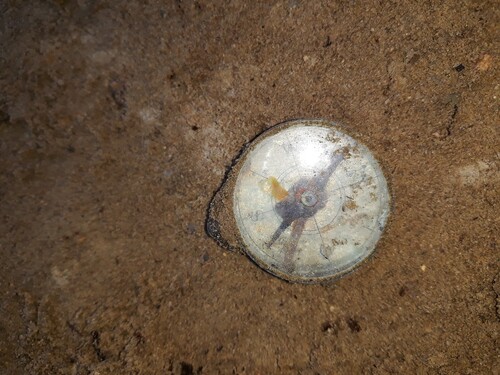 Fotografia przestawiająca przedmiot odnaleziony na stanowisku ekshumacyjnym.