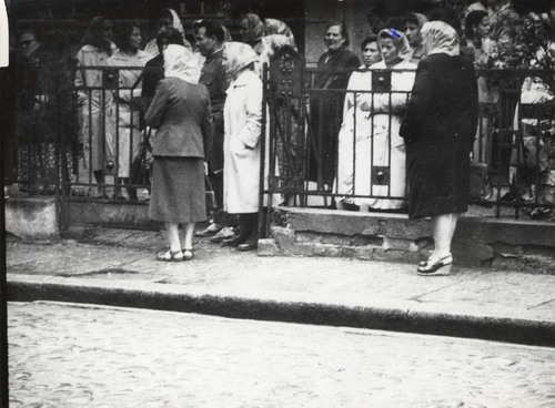Grupa kobiet stojący przy ogrodzeniu z otwartą furktą