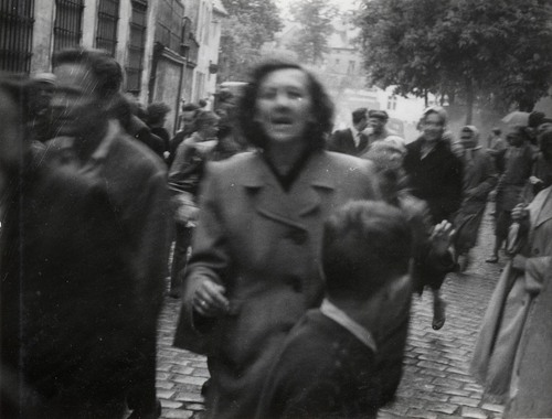 Grupa osób na ulicy, na pierwszym planie twarz kobiety w młodym wieku