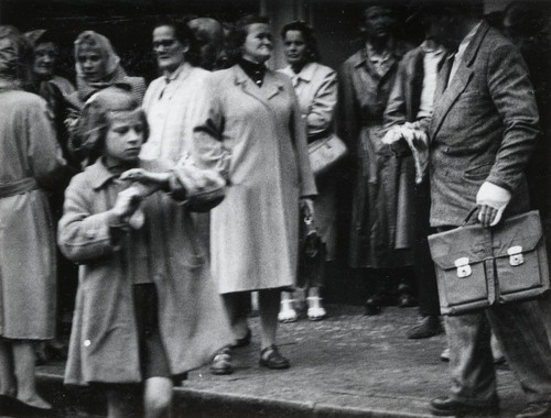 Grupa osób na ulicy, na pierwszym planie postać małej dziewczynki
