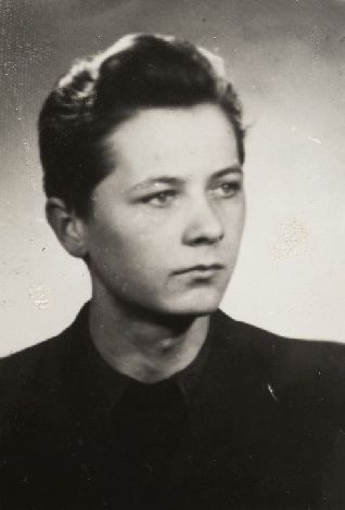 Fotografia portretowa młodego mężczyzny: poważny wyraz twarzy, ciemne, pofalowane włosy.