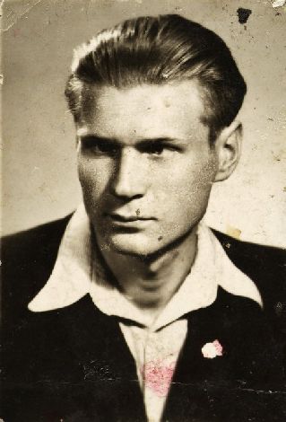 Fotografia portretowa młodego mężczyzny: włosy zaczesane do tyłu, biała koszula z wywiniętymi na marynarkę kołnierzykami.