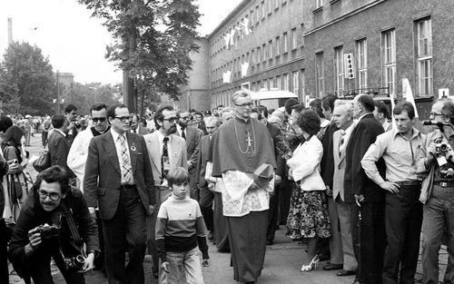 Ceremonia odsłonięcia Czerwcowej tablicy pamiątkowej przed Fabryką Lokomotyw i Wagonów HCP, 27 czerwca 1981 r. Wśród ludzi zgromadzonych na uroczystości przechodki kard. Franciszek Macharski w stroju kardynalskim.