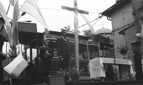 Uroczystość odsłonięcia tablicy pamiątkowej przy ul. Gajowej, w czasie obchodów 25. rocznicy Poznańskiego Czerwca 1956, 27 czerwca 1981 r. Ołtarz polowy, którego tło (tylną ścianę) stanowi zabudowa wagonu tramwajowego, przy którym ustawiono biały krzyż z napisem: 1956 - 1981. Obok m.in. flagi narodowe.