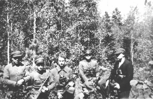 Zdjęcie mężczyzn z karabinami, pozujących w lesie do zdjęcia