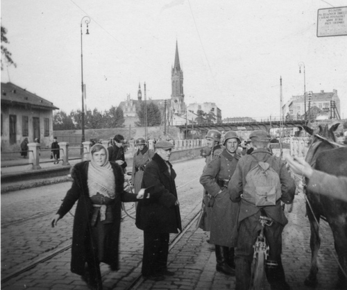 Patrol niemiecki kontroluje na ulicy ludność cywilną wjeżdżającą do miasta