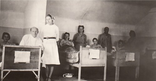 Oddział gruźliczy szpitala Polskiego Czerwonego Krzyża. Na pierwszym planie doktor Jan Jodłowski, obok stoi pielęgniarka L. Połońska; w łóżkach leżą byłe więźniarki.