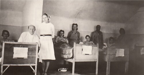 Oddział gruźliczy szpitala Polskiego Czerwonego Krzyża. Na pierwszym planie doktor Jan Jodłowski, obok stoi pielęgniarka L. Połońska; w łóżkach leżą byłe więźniarki.