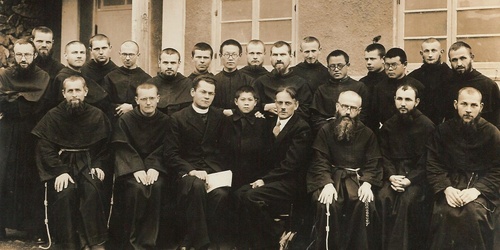 Grupa zakonników i młodych mężczyzn pozuje wspólnie do zdjęcia