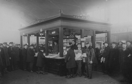 Grupa ludzi przed kioskiem Tow. "Ruchu" S.A. na Dworcu Głównym w Warszawie, 1928 r. Fot. ze zbiorów NAC