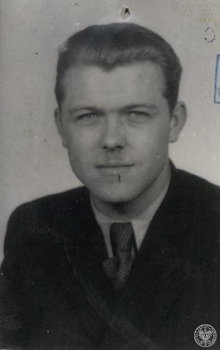 Jerzy Kaskiewicz (zdjęcie z akt z 1947 roku). Na zdjęciu jest młody mężczyzna o nieco wydatnych policzkach, z niedużym wąsikiem, starannie zaczesanych do tyłu włosach, ubrany w koszulę, krawat i marynarkę.