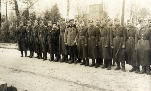 Byli żołnierze oddziału Batalionów Chłopskich „Ośki” jako słuchacze szkoły oficerskiej Milicji Obywatelskiej w Łodzi, wiosna 1945 roku. Na zdjęciu widać dwuszereg umundurowanych funkcjonariuszy (mężczyzn) - pomiędzy nimi stoją także dwie osoby ubrane po cywilnemu: jedna kobieta i jeden mężczyzna.