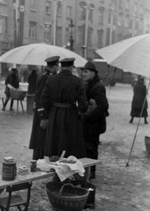 Policjanci (granatowi) podczas rozmowy z mężczyzną na targowisku. Fot. ze zbiorów NAC