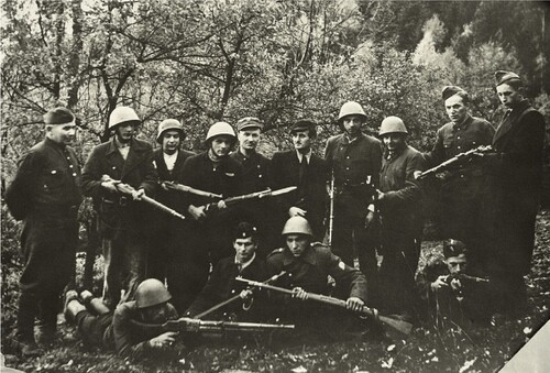 Oddział Partyzancki Armii Krajowej „Chełm” w Sidzinie jesienią 1944 roku. Pozowane zdjęcie grupy konspiratorów. Mężczyźni ubrani są bardzo różnie, w ubrania z przewagą elementów cywilnych, choć niektórzy mają też na sobie elementy wojskowe (jak kurtki mundurowe, czy hełmy). Większość konspiratorów trzyma w dłoniach broń piechoty (karabiny). Zdjęcie wykonane w zagajniku.