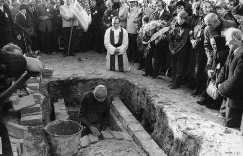 Grupa osób modlących się podczas pochówku doczesnych szczątków księdza Jerzego Popiełuszki