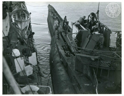 U-1165 przygotowuje się do operacji holowania przy burcie ORP Krakowiak w zatoce Lough Foyle prawdopodobnie 29 grudnia 1945 r. Krakowiak dwukrotnie podejmował na hol tego U-Boota. Za pierwszym razem, 29 grudnia, z powodu zerwania liny holowniczej oba okręty zostały w bazie. Następnego dnia Krakowiak wyruszył z U-1165 na wyznaczone miejsce, gdzie U-Boota zatopiły ogniem dział brytyjskie niszczyciele Fot. z zasobu IPN ze zbioru kopii cyfrowych fotografii Stow. Weteranów Armii Polskiej w Ameryce