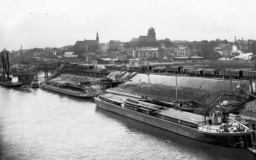 Port w Tczewie w okresie międzywojennym. Widok nadbrzeża z barkami. Na drugim planie widoczne wagony towarowe. Fot. ze zbiorów NAC