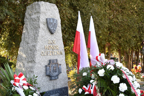 Odlew Krzyża Armii Krajowej umieszczony na pomniku przy kwaterze żołnierzy AK na Centralnym Cmentarzu Komunalnym w Katowicach. Na kamiennym obelisku również przedstawienie Orła Białego w oraz napis: BÓG, HONOR, OJCZYZNA. Wokół wiązanki kwiatów.
