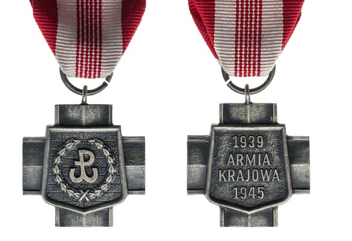 Skan awersu i rewersu Krzyża Armii Krajowej, którym pośmiertnie został odznaczony por. Jan Nycz. Krzyż równoramienny, w środku tarcza symbolizująca mur i znak kotwicy (symbol Polski Walczącej – przyjęte także jako znak środowiskowy Koła AK) w otoczeniu wieńca. Na odwrocie napis: 1939, ARMIA KRAJOWA, 1945. Wstążka o barwach narodowych, biało-czerwona, po środku sześć pasków symbolizujących lata walki w konspiracji.