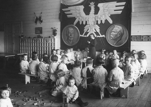 Przedszkole Rodziny Kolejowej w Radomiu, ok 1935 r. Fot. z zasobu NAC. Dzieci podczas zabawy. Na ścianie widoczna dekoracja: stylizowany orzeł, wizerunki Ignacego Mościckiego i Józefa Piłsudskiego.