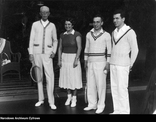 Trzech mężczyzn i kobieta, wszyscy w strojach tenisowych, pozują do zdjęcia
