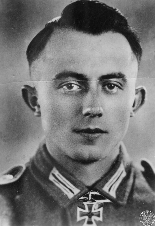 Starszy kapral Oswin Göttert z 134 Dywizji Piechoty otrzymał Krzyż Rycerski Krzyża Żelaznego 7 września 1943 r. za zasługi w czasie walk z wojskami sowieckimi. Agencja (prawdopodobnie Scherl) wykorzystała wcześniejszy portret, na którym doklejono odznaczenie wycięte z innej fotografii. Jest to szczególnie widoczne na wyraźnie odcinającej się od tła wstążce, zawieszanej z odznaczeniem na szyi. Fot. z zasobu AIPN