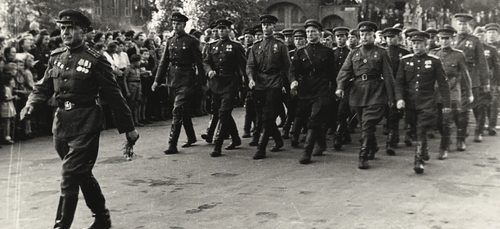 Grupa maszerujących żołnierzy w sowieckich mundurach