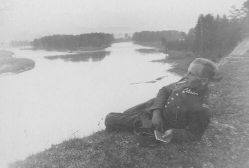 Stanisław Bielański nad brzegiem rzeki. Na zdjęciu widać młodego mężczyznę w mundurze podchorążego Wojska Polskiego, leżącego na wysokim brzegu szerokiej rzeki i palącego papierosa. Fotografia ze zbiorów rodziny Bielańskich.