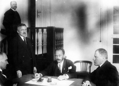 Wicemarszałek Sejmu Zygmunt Seyda (stoi), poseł Karol Polakiewicz (siedzi na wprost), sędzia Najwyższego Trybunału Administracyjnego Włodzimierz Wyganowski (z prawej), wiceminister sprawiedliwości Julian Siennicki w dniu otwarcia sesji sejmowej, 28 listopada 1922 r. Fot. ze zbiorów NAC