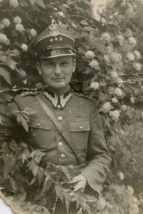 Kapitan Stefan Domaradzki - zdjęcie wykonane w mundurze na tle kwitnącego krzewu lub niewielkiego drzewa