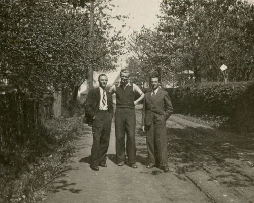 Trzech mężczyzn pozujących do zdjęcia w plenerze