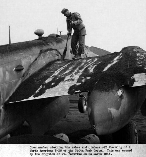 Crew member brushing off the ash from the wings of an American bomber B-25 Mitchell from the 340th Bomb Group, March 23rd, 1944 (public domain)