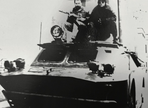Dwóch mężczyzn siedzących na czołgu