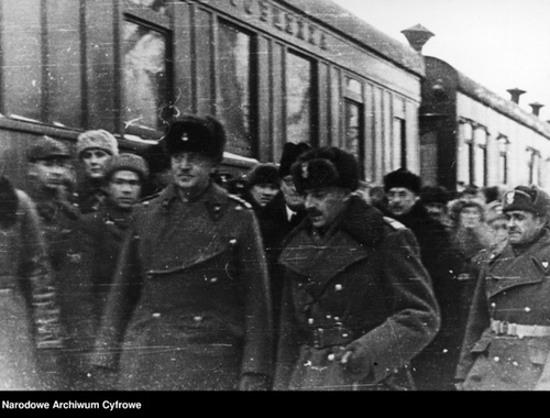 Mężczyzni, z przodu widoczni generałowie Anders i Sikorski, stoją na peronie kolejowym w zimowych mundurach