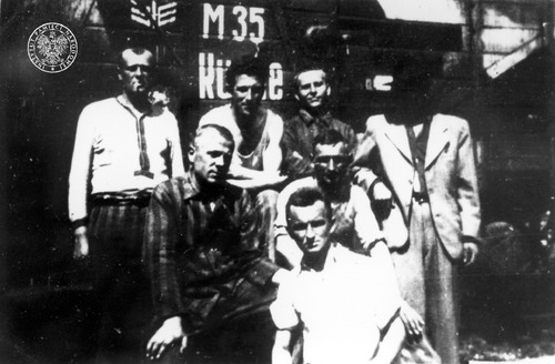 Grupa więźniów na tle rampy kolejowej. KL Buchenwald