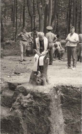 Ks. Zdzisław Peszkowski modli się przy dołach śmierci w Charkowie-Piatichatkach, gdzie znaleziono szczątki polskich oficerów zamordowanych w 1940 r. Fot. Andrzej Świderski