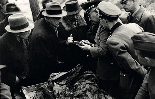Gerhard Buhtz - w mundurze, czwarty z prawej - pokazuje członkom komisji ekshumacyjnej dokumenty znalezione przy ciele ofiary