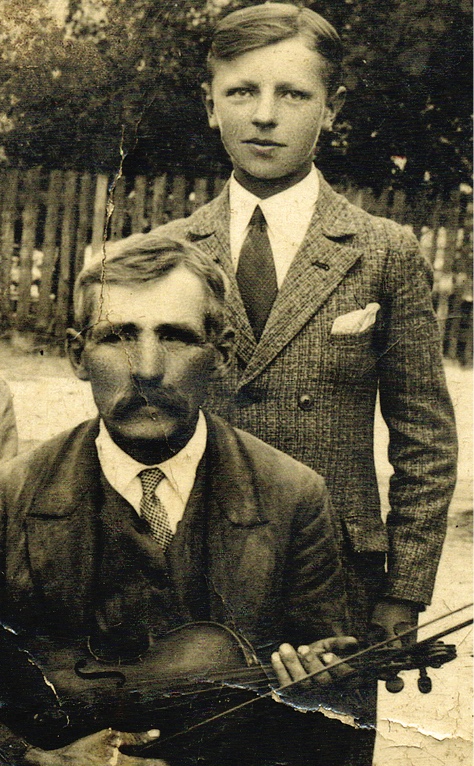 Jan Rogulka pozuje do zdjęcia ze swoim ojcem Józefem. Starszy mężczyzna trzyma skrzypce