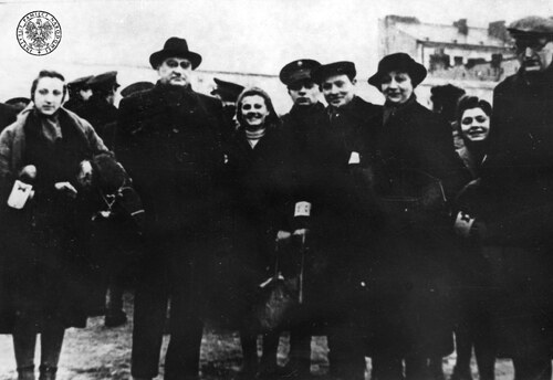 Adam Czerniaków, prezes Judenratu w getcie w Warszawie - drugi od lewej - w grupie kobiet i mężczyzn na ulicy