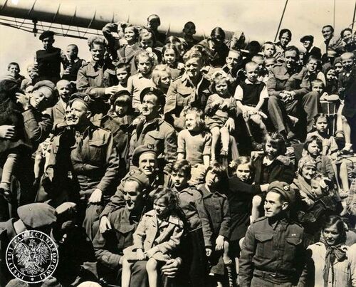 Liczna grupa polskich dzieci ewakuowanych ze Związku Sowieckiego i żołnierzy nowozelandzkich pozuje na pokładzie alianckiego transportowca płynącego do Nowej Zelandii