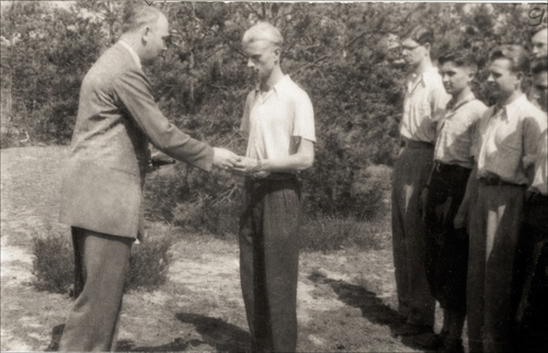 Konspiracyjna Szkoła Podchorążych Rezerwy Piechoty Agrykola; porucznik Eugeniusz Konopacki pseudonim Trzaska, Gustaw wręcza odznakę ukończenia kursu sierżantowi Andrzejowi Łukoskiemu pseudonim Blondyn