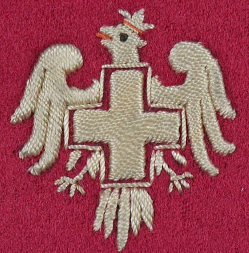 Naszywka Polskiego Białego Krzyża, pochodząca ze zbiorów Sokolstwa Polskiego w Ameryce przekazanych do Archiwum IPN w 2019 r. Fot. z zasobu AIPN