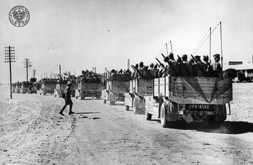 Kolumna samochodów ciężarowych jednej z jednostek Polskich Sił Zbrojnych na Bliskim Wschodzie (prawdopodobnie z Samodzielnej Brygady Strzelców Karpackich) na drodze podczas jazdy. (fot. z zasobu IPN)