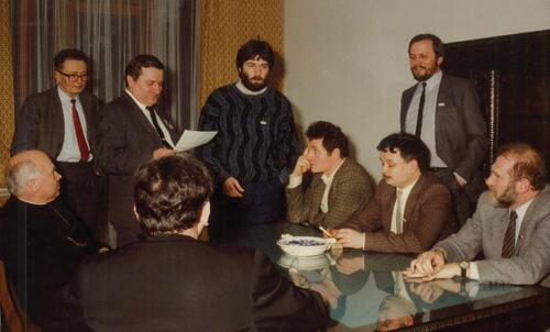 Narada przedstawicieli opozycji w trakcie rozmów ze stroną rządową w ośrodku MSW w Magdalence. Od lewej: bp Tadeusz Gocłowski (siedzi), prof. Witold Trzeciakowski, Lech Wałęsa, Władysław Frasyniuk, Zbigniew Bujak, Lech Kaczyński, Mieczysław Gil (stoi), prof. Bronisław Geremek; na pierwszym planie siedzi tyłem ks. Alojzy Orszulik, 2 III 1989 r. (fot. z zasobu IPN)