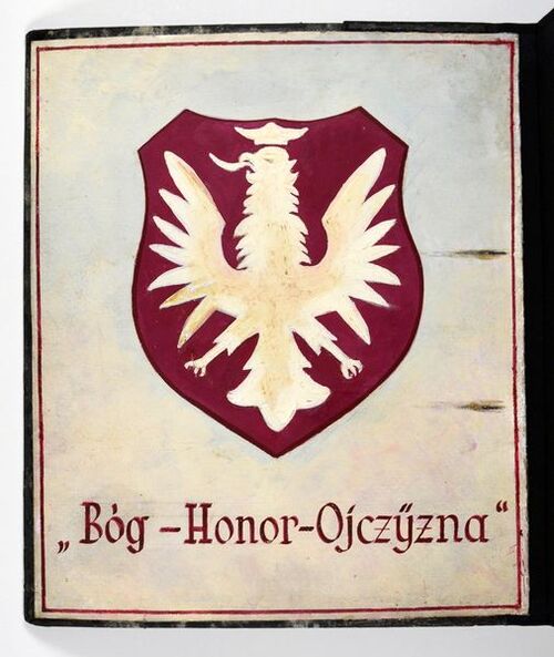 Ręcznie wykonana plakietka orła białego i napisem Bóg-Honor-Ojczyzna, pochodząca ze znajdującego się w Archiwum IPN zespołu: Zbiór „Ob” akt obozowych i więziennych zawierający fragmenty akt niemieckich wytworzonych przez kancelarie obozów i więzień lub urzędy związane z ich działalnością