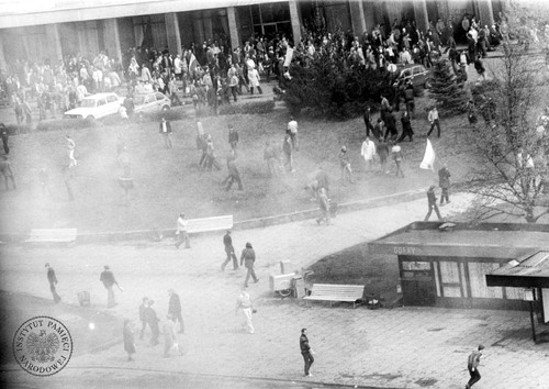 Demonstracja w dniu 1 maja 1983 r. w okolicach dworca PKP w Gdańsku (parku i nieistniejącego obecnie placu Gorkiego). Nad całym terenem unosi się dym, pośrodku stoi samotny saturator (fot. z zasobu AIPN)