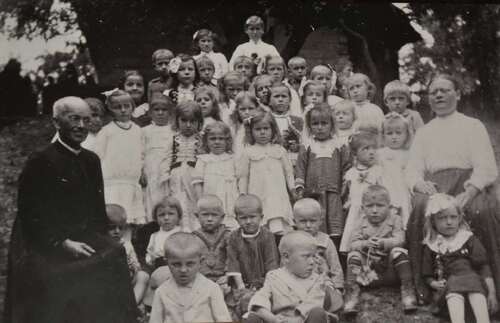 Ksiądz Franciszek Gołba pośród dzieci z ochronki w Bachowicach, z prawej – opiekunka Maria Momot. Fotografia ze zbiorów Kazimierza Dębskiego (Archiwum Gminnej Biblioteki Publicznej w Spytkowicach)